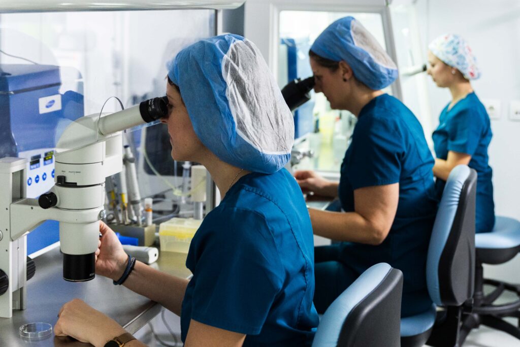 Drei Mitglieder des Embryolab Klinikteams in Thessaloniki analysieren Proben unter dem Mikroskop