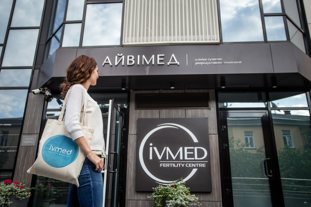 Eine Patientin steht vor dem Gebäude der IVMED Fertility Clinic Ukraine und betrachtet die Klinik