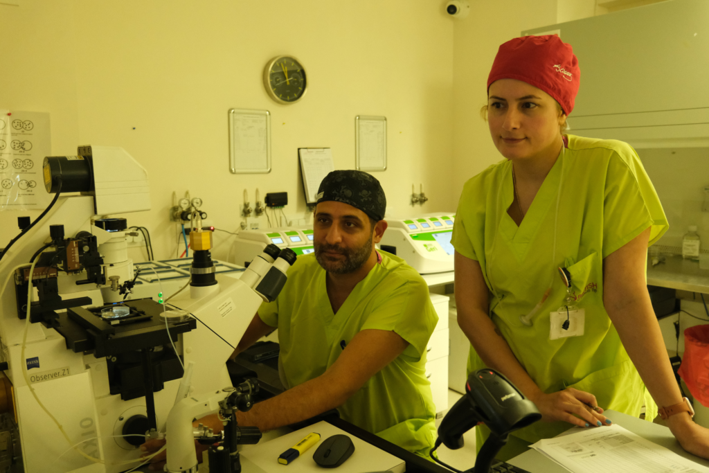 Zwei Embryologen in der British Cyprus IVF-Klinik arbeiten im Labor mit einem Mikroskop während des IVF-Prozesses.