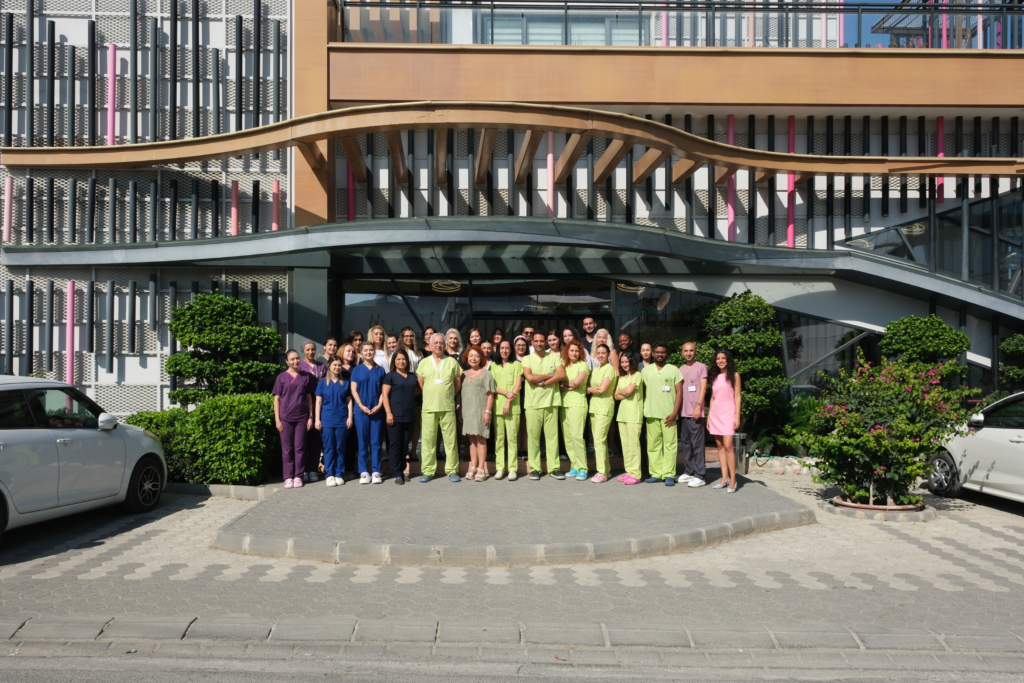Große Mitarbeitergruppe posiert vor der British Cyprus IVF-Klinik und repräsentiert das professionelle IVF-Team.